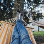 Person relaxing in comfortable hammock in outdoor garden setting