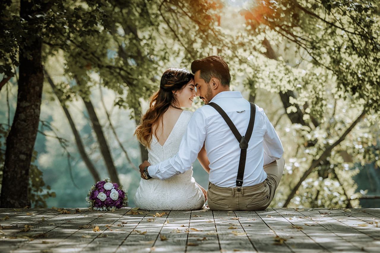 Couple holding hands during vow renewal ceremony at sunset outdoors