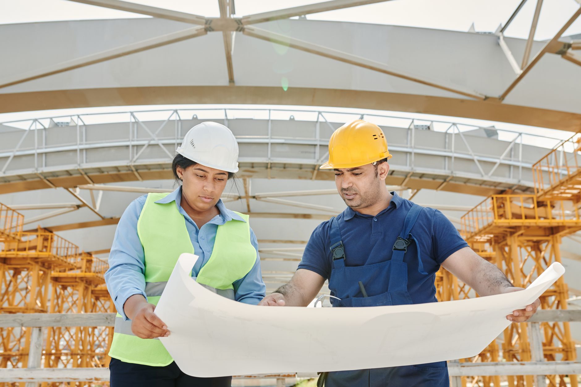 construction site manager leading team with blueprints and project planning