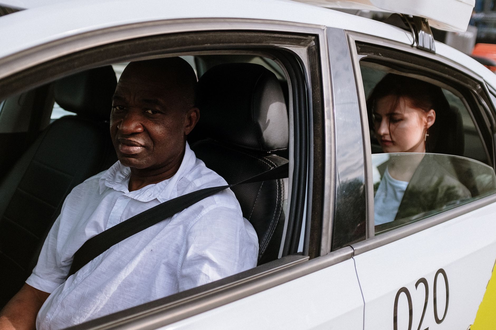 Professional taxi driver in Abingdon helping passenger with luggage at car