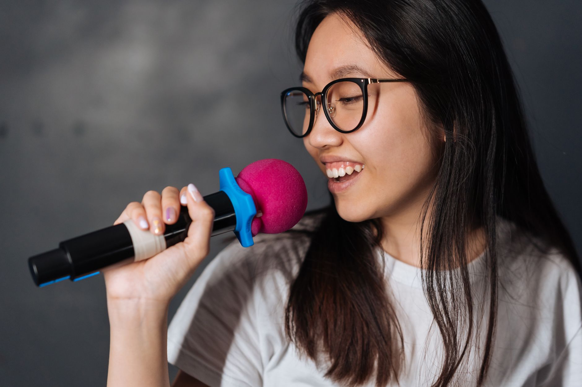 Group of friends singing karaoke together at a microphone in a social setting