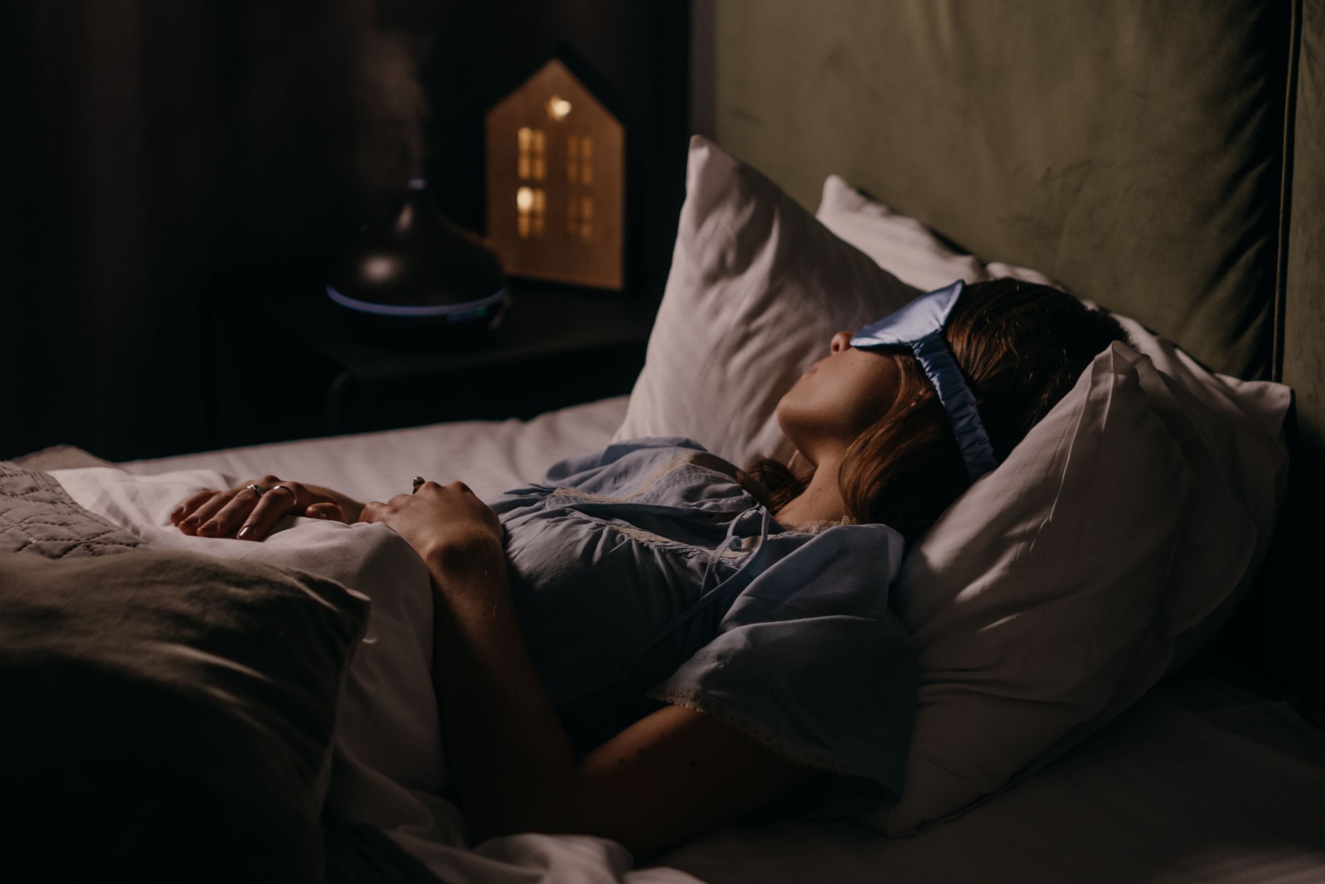 Person sleeping peacefully in bed at night with calm bedroom environment