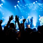 Concert crowd with raised hands enjoying live music performance