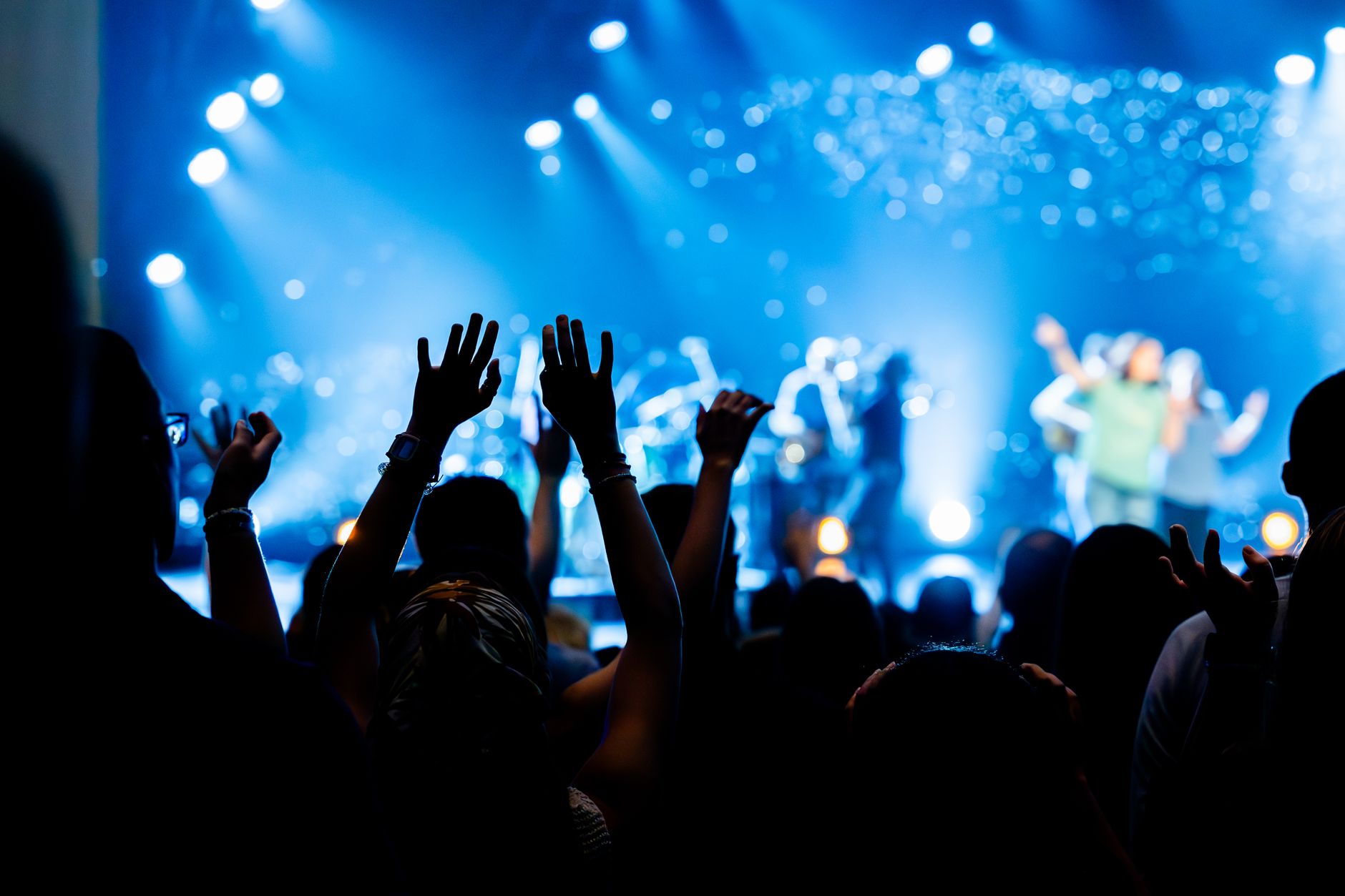 Concert crowd with raised hands enjoying live music performance