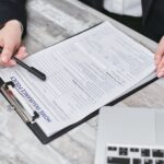 Person reviewing health insurance enrollment documents and options on laptop