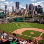 Baseball player mid-swing at plate during live game action